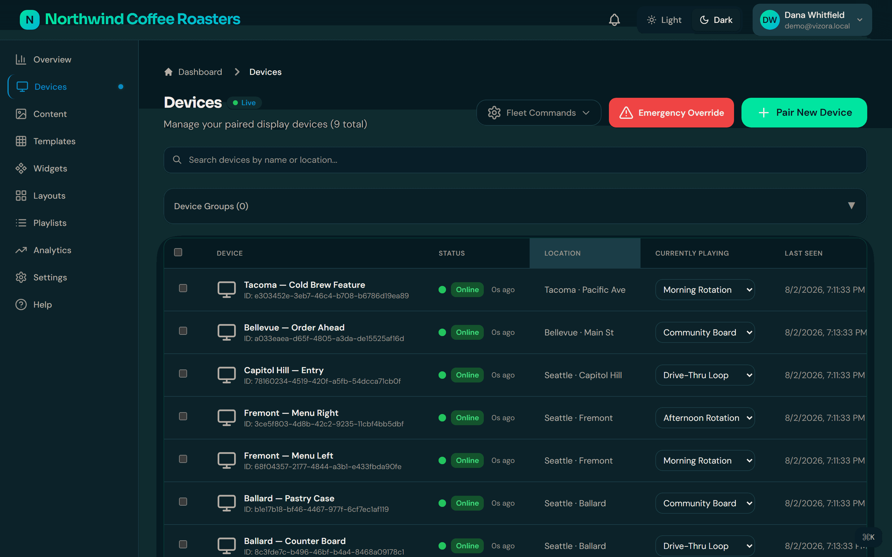 The Vizora devices view: a fleet of displays across Seattle-area locations, each row showing its connection status, the playlist assigned to it, and when it last checked in.